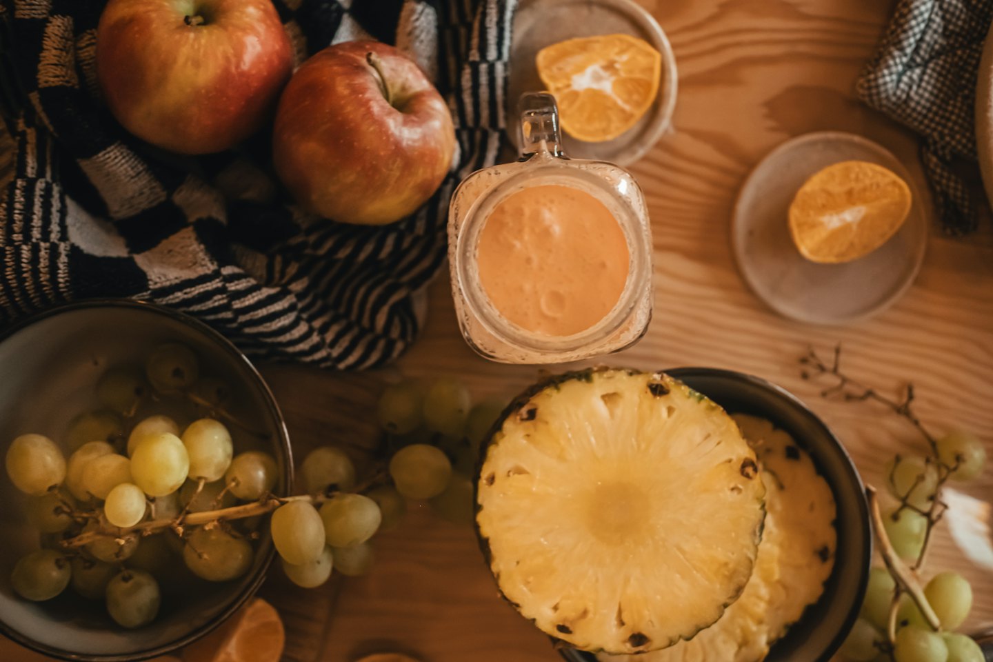 Čerstvé ovocné a pomerančové smoothie na dřevěném stole.
