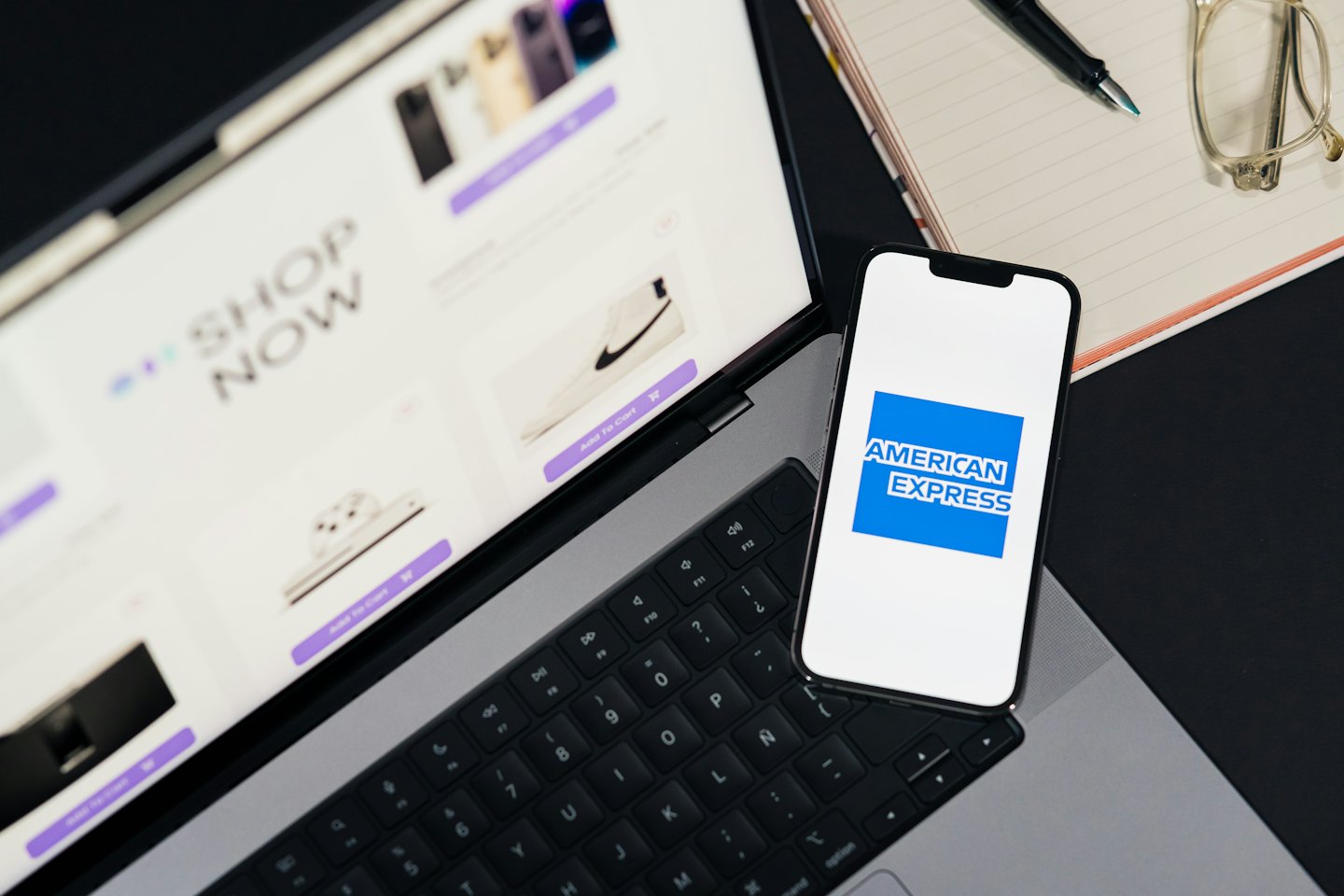 Notebook s otevřeným online obchodem vedle chytrého telefonu.