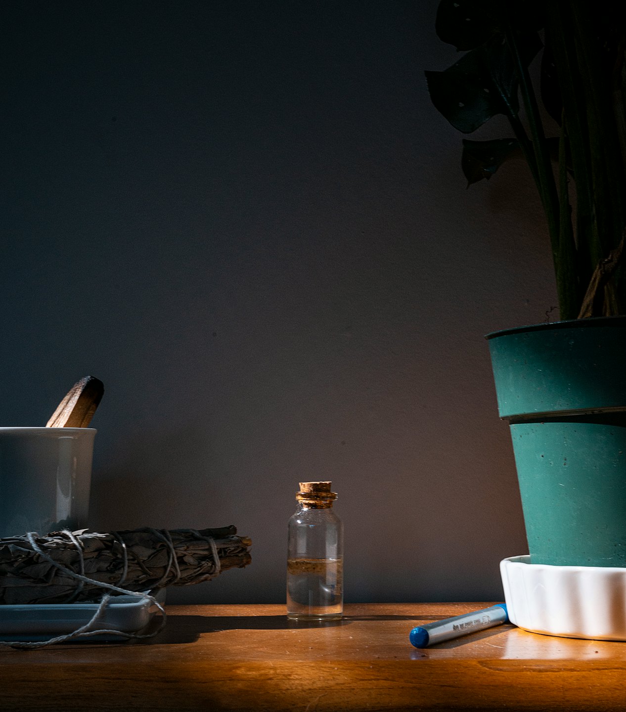Wellnessové předměty včetně šalvěje a oleje leží na dřevěném povrchu.