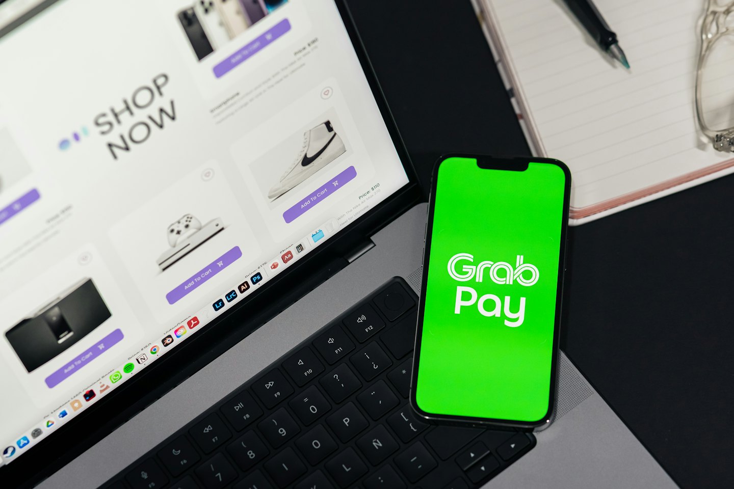 Notebook zobrazující e-shop vedle chytrého telefonu s platební aplikací.